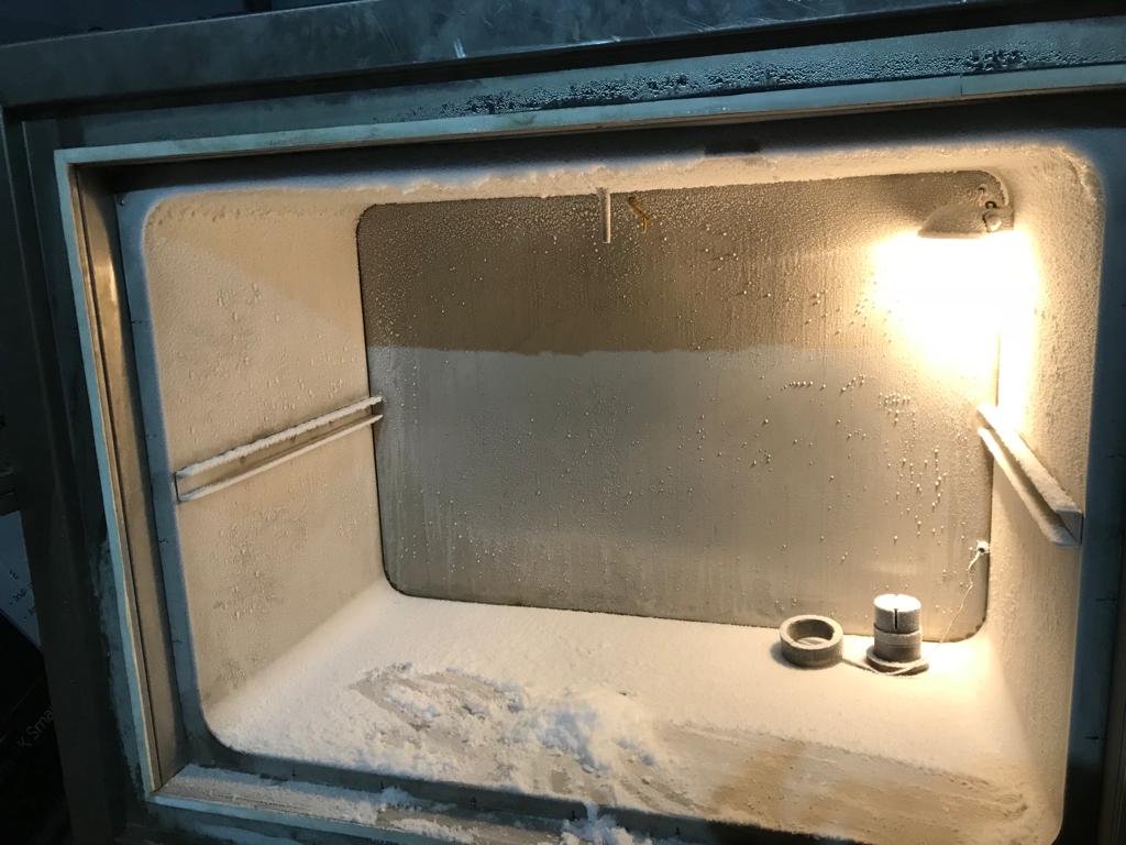 people holding umbrellas on a busy street at night lit by street lights and illuminated signs in Tokyo, Japan
